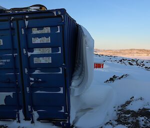 The snow peeling away from the shipping container.