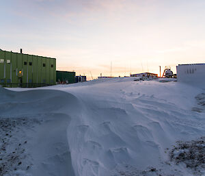 A mass of snow that has been deposited behind the Sleeping Medical Quarters.