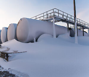 The fuel tanks have a blanket of snow on them.