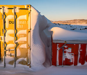 Shipping containers with a thick layer of snow.