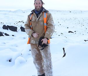 A photo of Bryce in his work gear, standing in the snow.