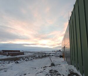 A view of the sunrise behind the work buildings on station.