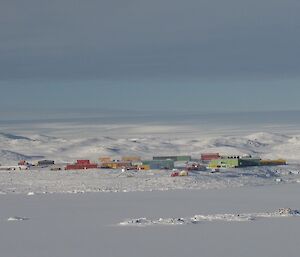 Davis — home. Snow covered Vestfold Hills behind station and the beloved sea-ice in Prydz Bay.