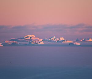 A pink sky at sunset over the icebergs off station.