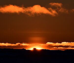 An orange sky with a setting sun. Our last sunset until the 10th July.