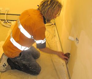 Rhys (carpenter), fills in the holes left by the electrician.