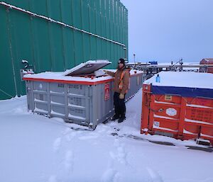 Shoey disposing of recyclables into a half height shipping container.