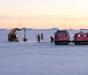 The auger being put into position to drill into the squares of ice to aid with removal.