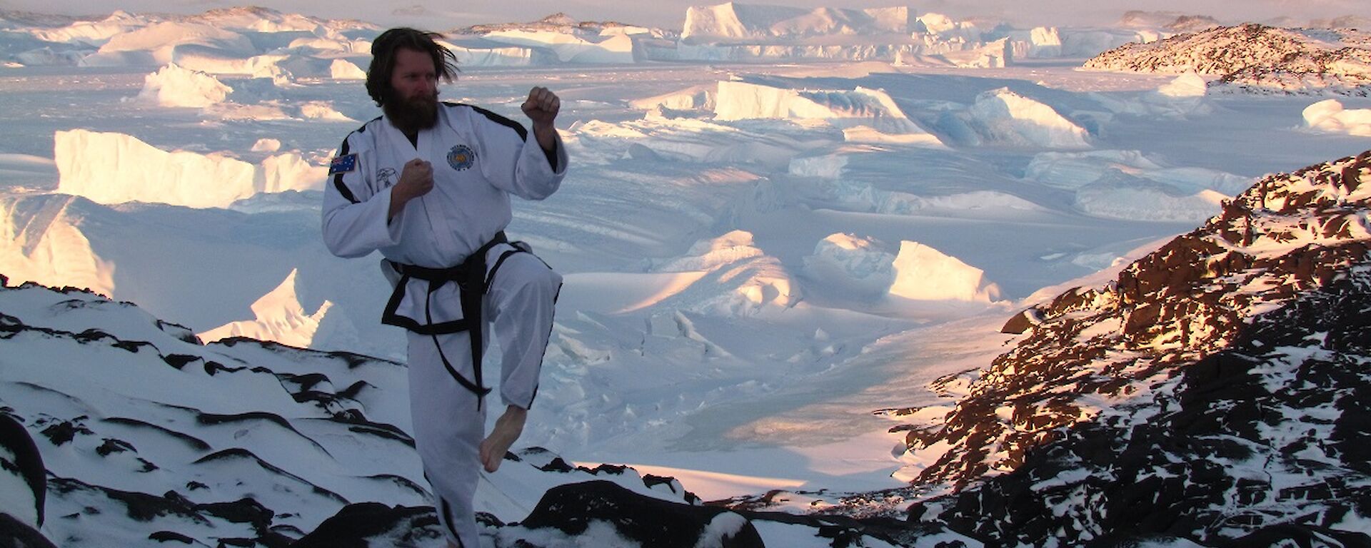 Sharky is in his TaeKwon-Do uniform, striking a pose at Bandits. In the background are icebergs and the Antarctic Plateau.
