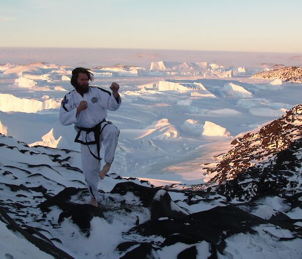 Sharky is in his TaeKwon-Do uniform, striking a pose at Bandits. In the background are icebergs and the Antarctic Plateau.