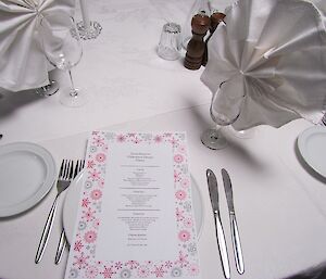 The midwinter dinner menu sitting on a plate on the table.