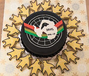 A fruit cake with our team’s logo on it, surrounded by penguin shortbread, all individually named.
