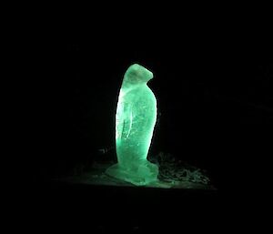 The penguin sculpture under green LED light.