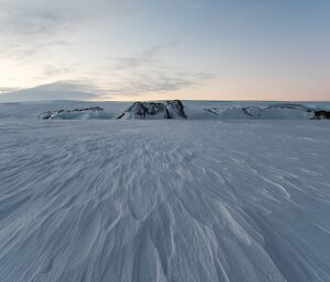 The windblown texture of the snow on the sea ice.