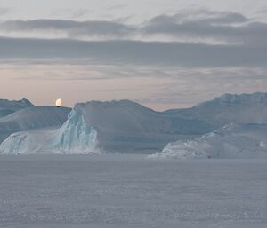 Icebergs with a rising moon.