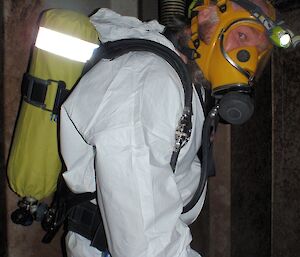 Fitzy is dressed in breathing apparatus protective clothing, including air tank and mask, to work in the confined space of a tank.,