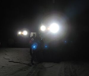 Two Hägg’s headlights reveal people standing on the sea-ice. This is early on in the trip, when it is dark and very cold.