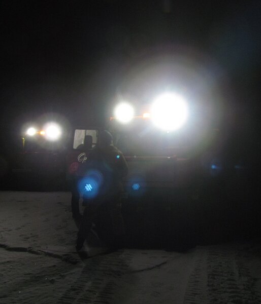 Two Hägg’s headlights reveal people standing on the sea-ice. This is early on in the trip, when it is dark and very cold.