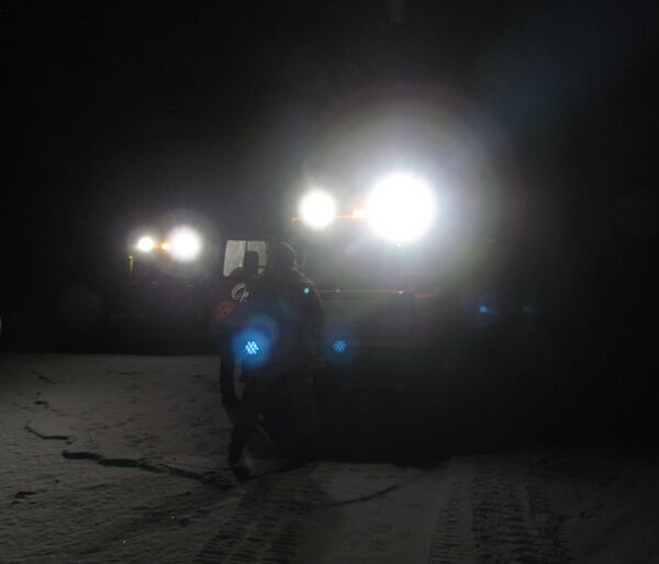 Two Hägg’s headlights reveal people standing on the sea-ice. This is early on in the trip, when it is dark and very cold.