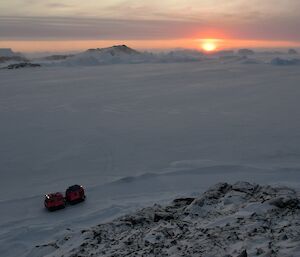 The sunrise in Tryne Fjord, two days earlier than on station. The sun is on the horizon. The hagg sits out on the seaice in front of Bandits Hut.
