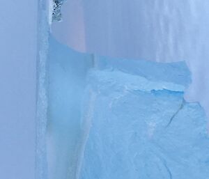 A towering iceberg frozen in sea ice; impressive in its height.