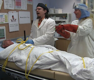 Another film scene: Robert is tied to the table in the Medical suite, Ralph is being the doctor and Kirsten is injecting Ralph with green fluid.