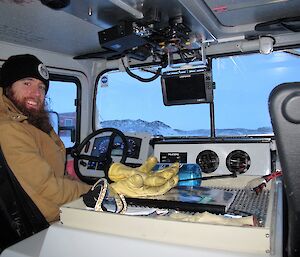 Shoey is sitting in the driver’s seat, driving the Hägg over the sea ice to Watts hut.