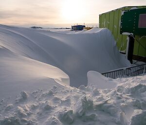 A massive snow dune exists in front of the living quarters building.