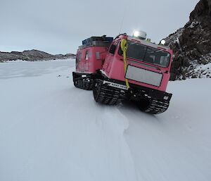 Putting the pink Hägg into position, simulating getting a track caught in a crevasse slot. The left side of the Hagg is angled down a slope so it now needs to be righted using ropes.