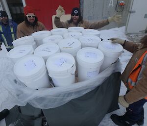 Fitzy, Lötter, Bryce and Shoey open a pallet containing buckets of dry goods.