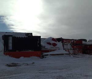 The Return To Australia cargo on the wharf. It consists of shipping containers piled quite high and still under a bit of snow.