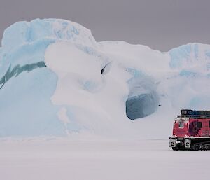 The dark grey sky and flat light bring out the pastel blues of the icebergs. This berg also has a jade stripe and a cave.