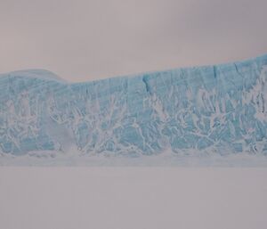 The horizontal lines of snow deposition are visible in this giant iceberg.