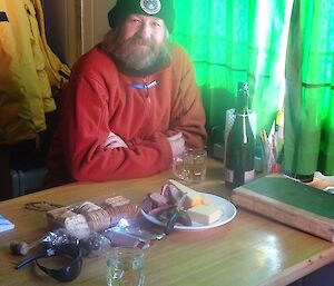 Fitzy is sitting at the table in Brookes hut enjoying cheese, wine and crackers. He’s looking relaxed and happy.