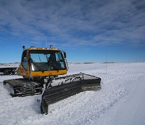 Jock in the groomer pushing snow — day one of making a runway.