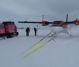 The pilots, Doug and Jeff, check the Twin Otter’s wing tie downs. Blizz covers the plane’s skis.