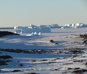 Distant icebergs in icy landscape.