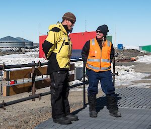 A man and a women standing outside talking.