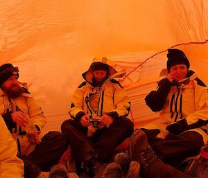 A group in an orange field shelter.