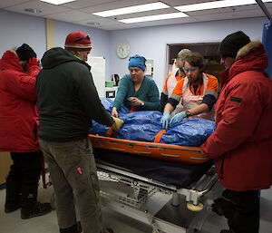 A medical team and patient on stretcher.