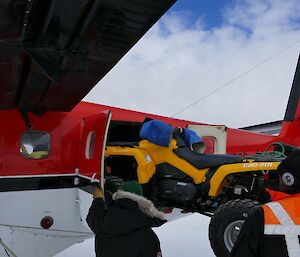 A quad bike is loaded into a plane.