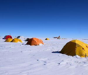 A camp of tents and plane on the ice.