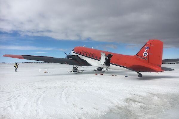 A twin engine skiplane on the ice.