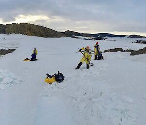 People dig in the snow to make a sleeping area.