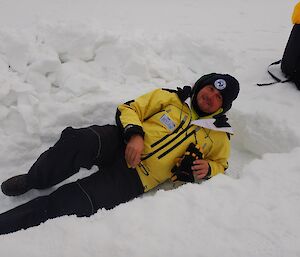 A man lies on the snow.