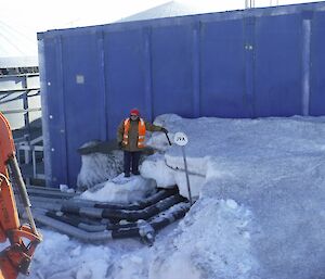 A man digs pipes from the snow