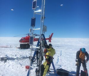 A team with a steel tower for instruments on the glacier.