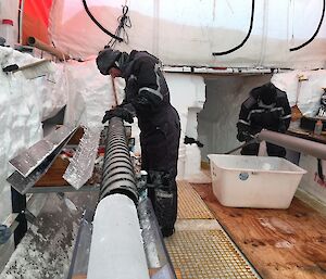 A man checks an ice core inside a tent