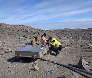 3 men work on equipment