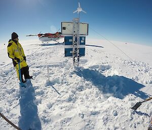 A man installs science gear with aeroplane behind